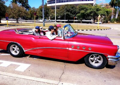 people-driving-and-riding-in-a-red-convertible-car