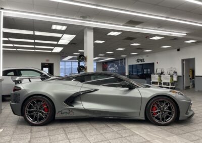 side shot of a silver sports car display in a building